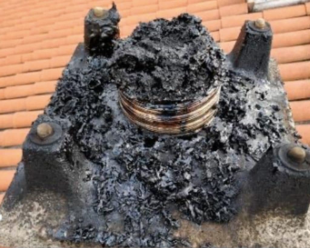 Quelle est la différence entre un ramonage et un débistrage ? photo représente un conduit de fumée mal entretenue.